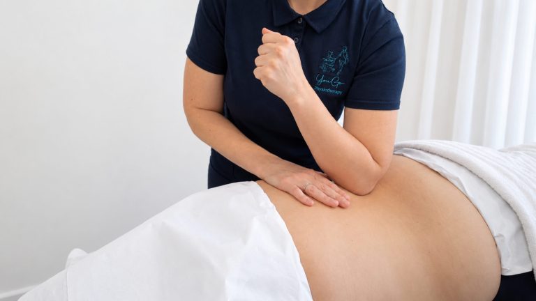 Physiotherapist performing treatment on patient's lower back at YouGo Physio.