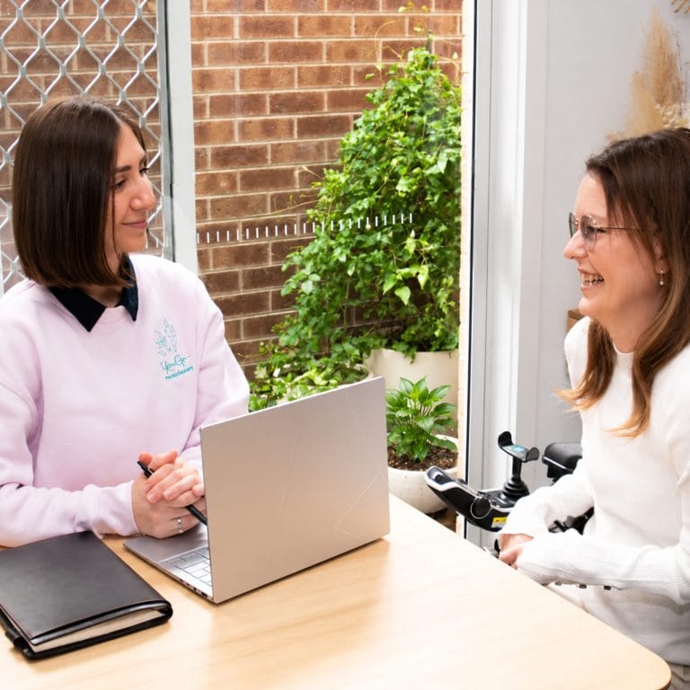 Physiotherapist consulting with a patient in a bright clinic setting.