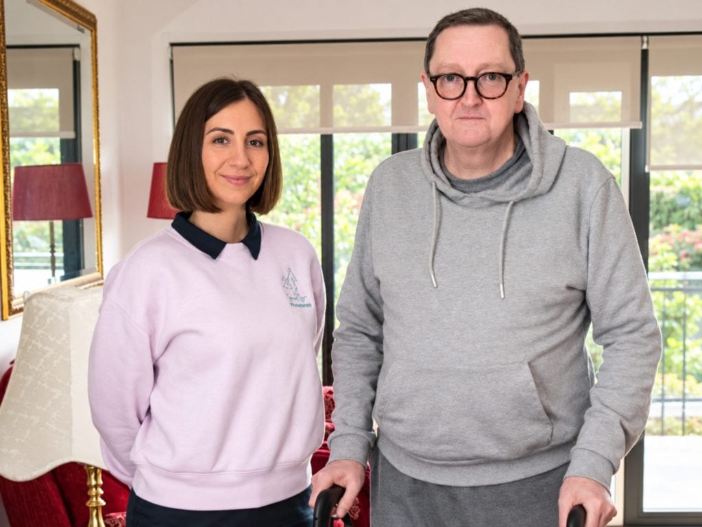 YouGo Physio staff member with a patient in a bright clinic setting.